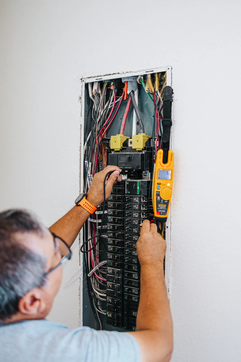 A Midway Electric electrician testing a home electrical panel in Columbia, MO