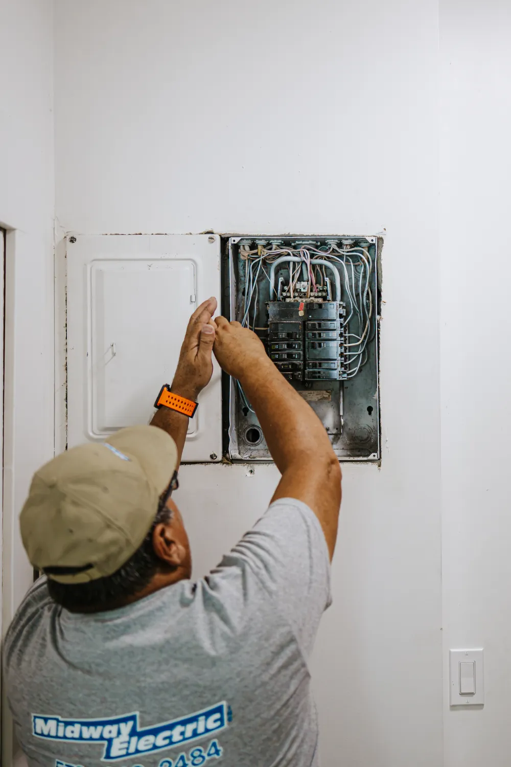 A Midway Electric electrician working on a home electrical panel